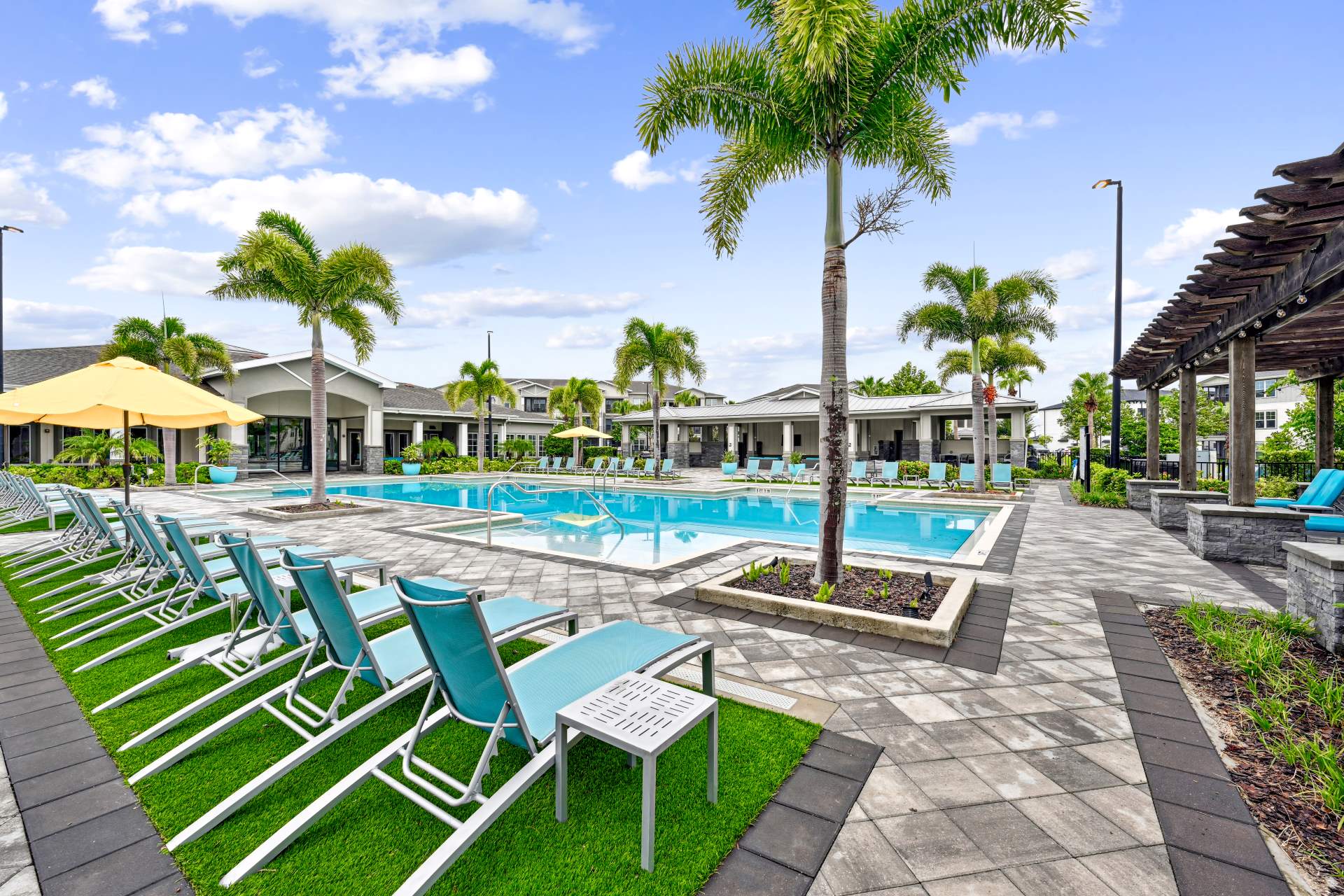 Large pool and sun deck with native palm trees and lounge chairs